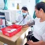 Nhân viên y tế đo huyết áp miễn phí cho người dân tại trạm y tế.